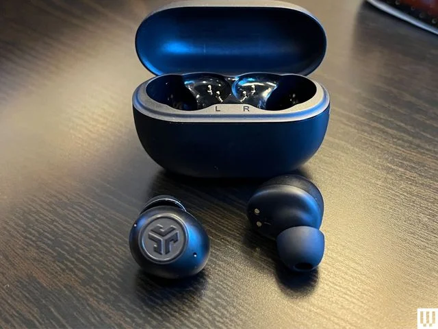 JLab Go Pop ANC, black ear buds in front of an open, black, oval-shaped case